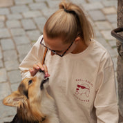 Woman wearing a 'Anti-Social Dog Owner' shirt petting a dog outdoors.